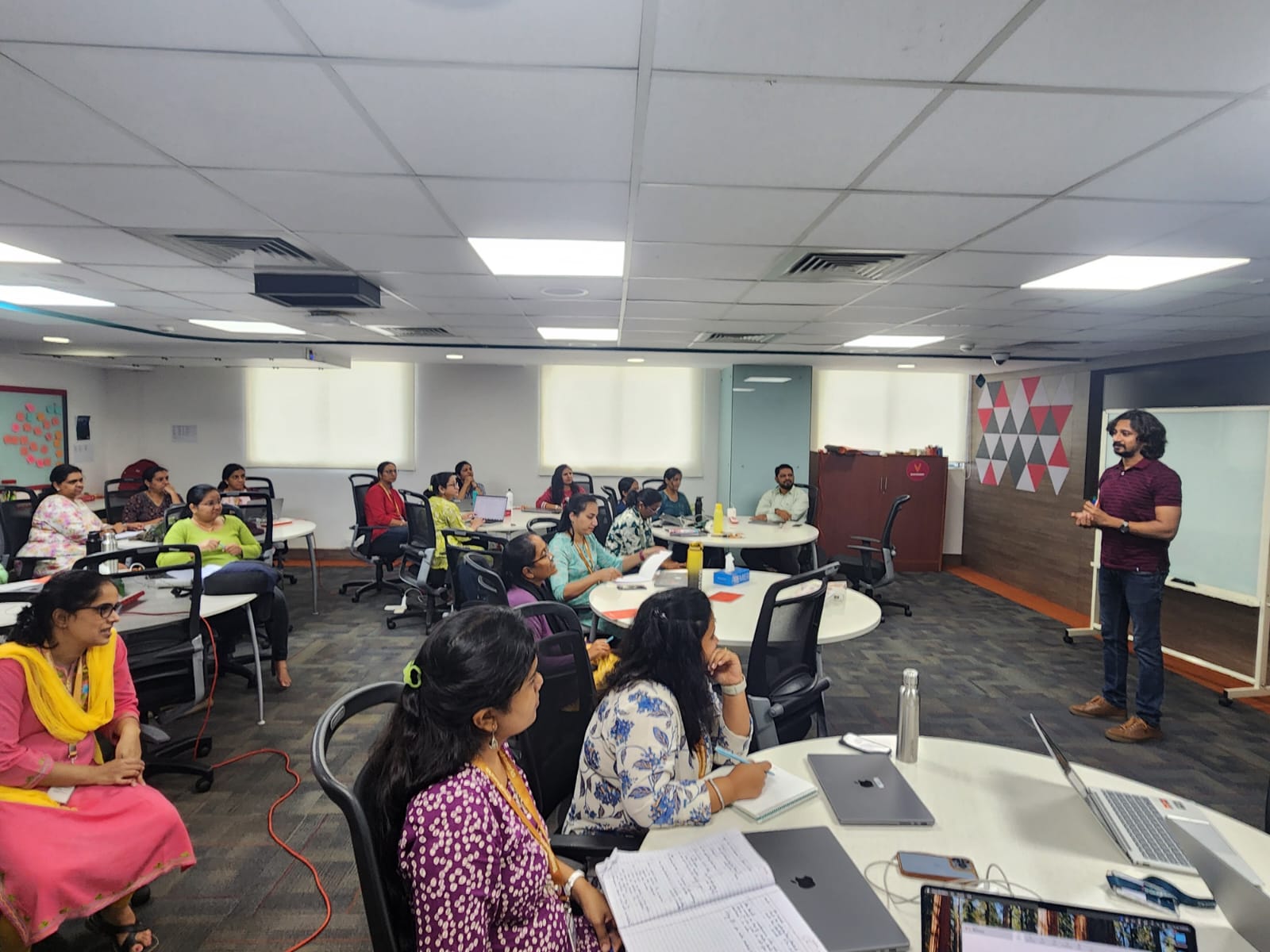 Interactive classroom with learners engaged around shared tables